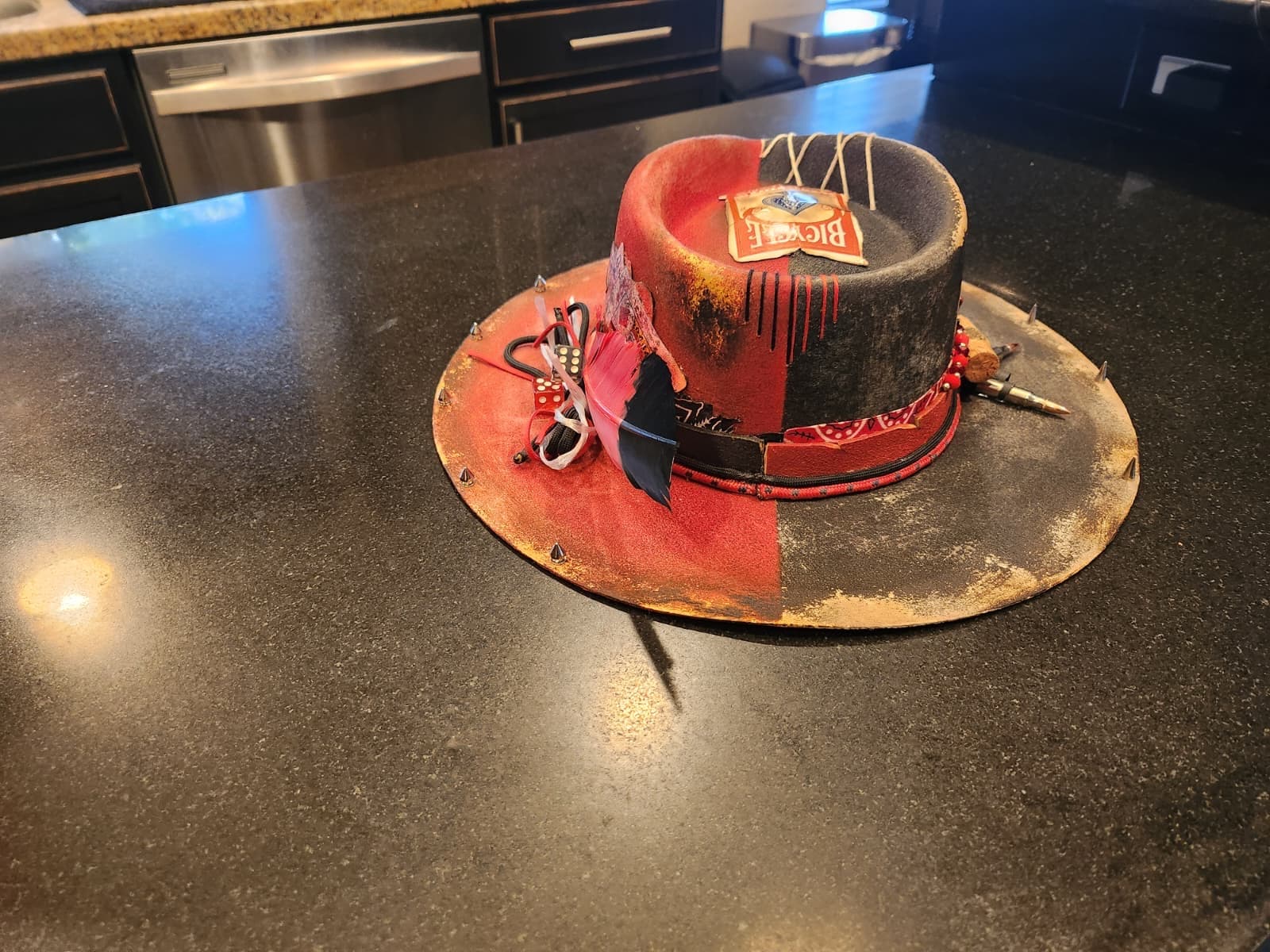 Hand-finished red and black hat with gold distressing and stitched details